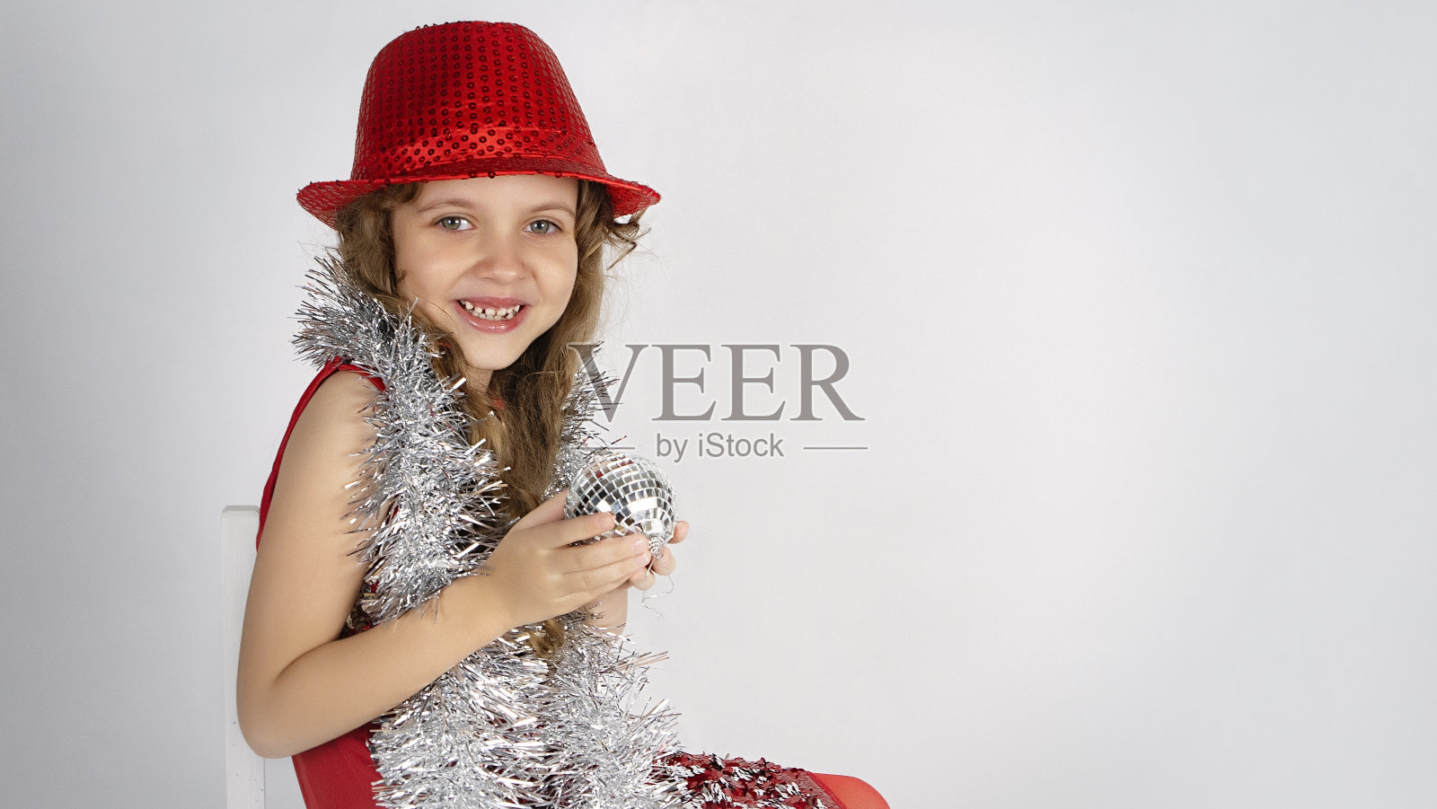 戴着红帽子和亮片的可爱小女孩照片摄影图片