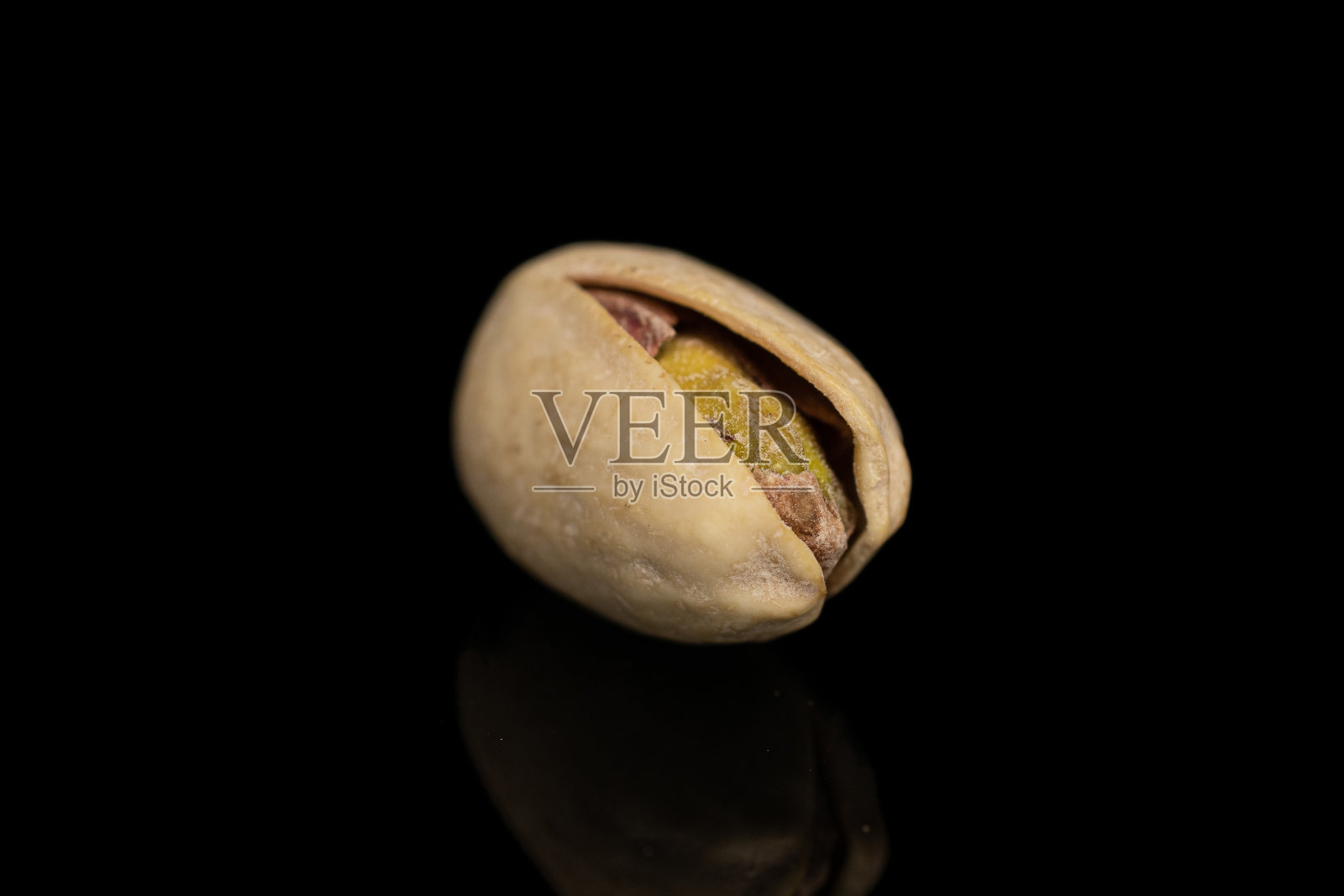 黑色玻璃上隔离的盐腌开心果照片摄影图片