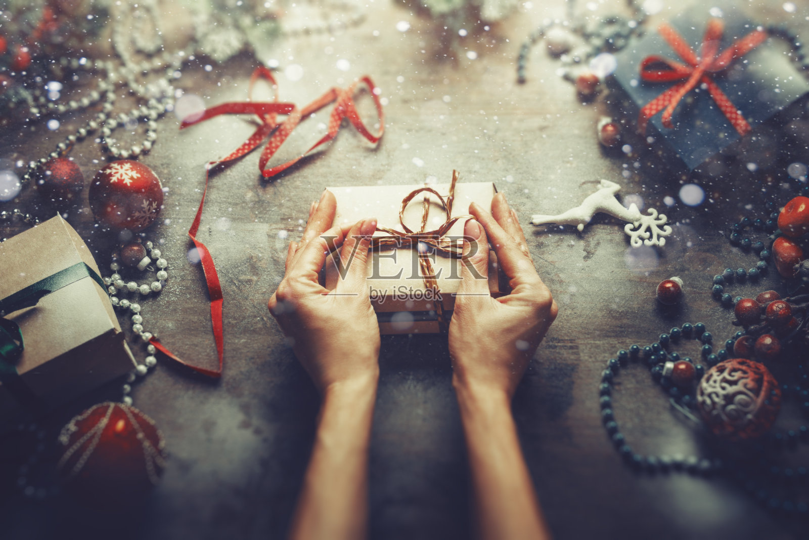 圣诞新年概念顶视图：一位无法辨认的女士在木桌上包装礼品盒照片摄影图片