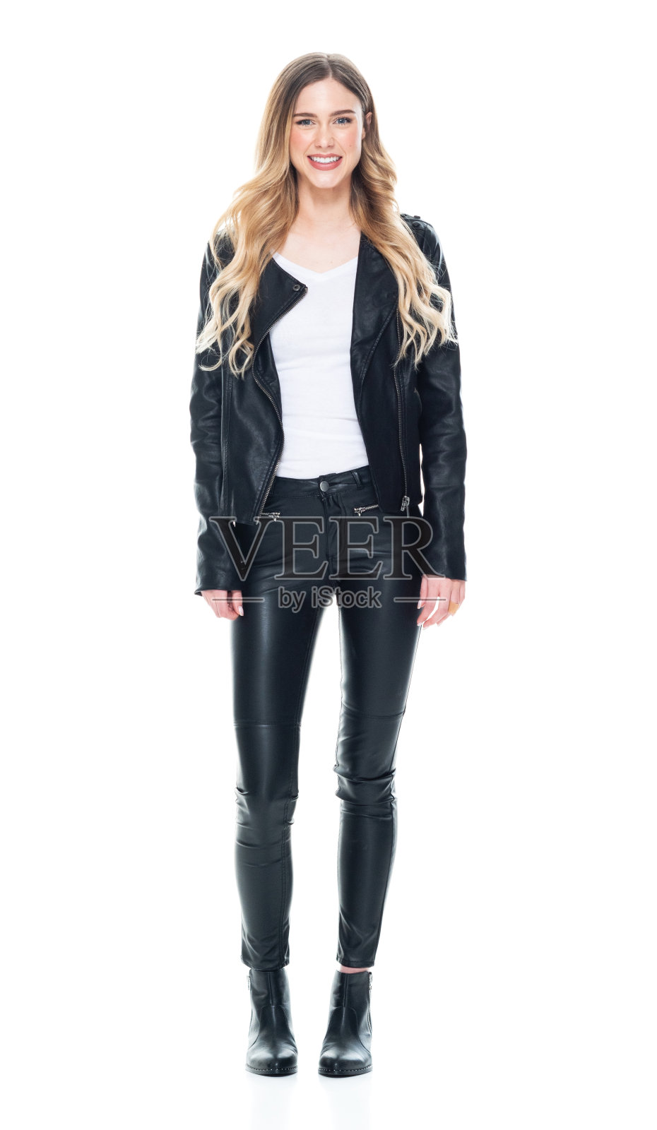全身/正面/看镜头/一个20-29岁的成年人漂亮的金发/长发白种人/ z一代女性/年轻女性站在皮夹克/裤子/靴子/ t恤/衬衫手拉手照片摄影图片