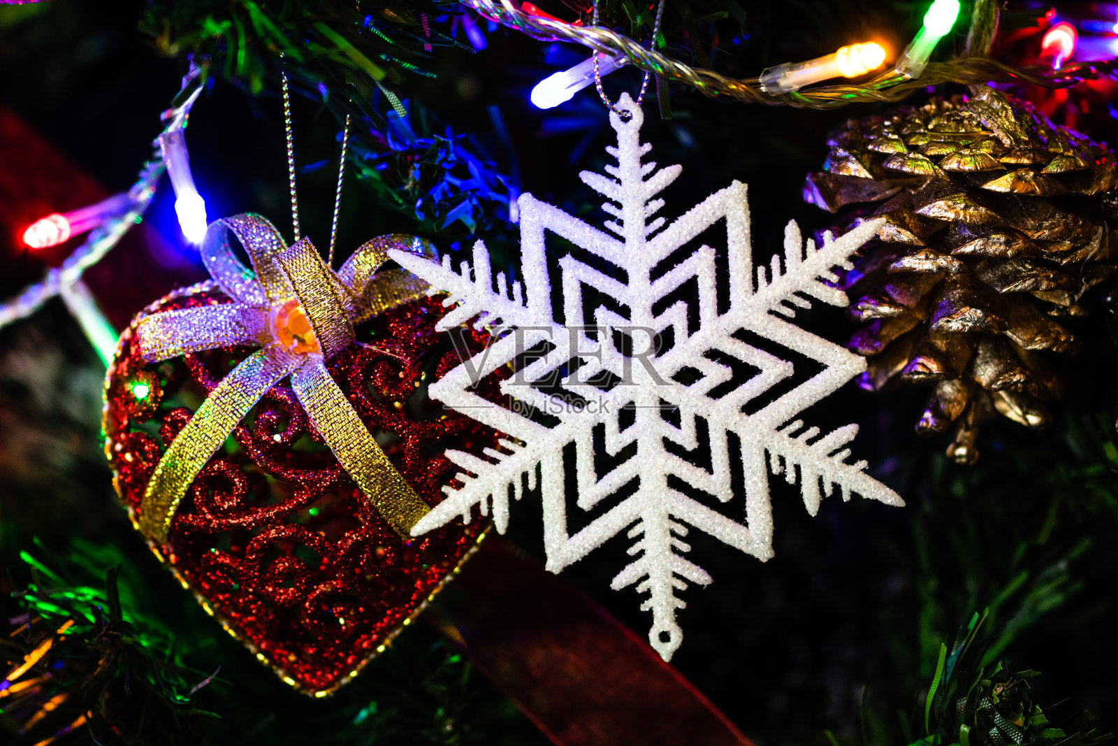 圣诞树上挂着圣诞节的装饰品。装饰圣诞树。冷杉枝上点缀着闪闪发光的雪花。照片摄影图片