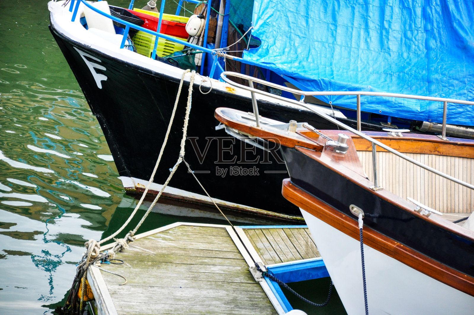 码头上有渔船，划艇，海滩上有彩木。照片摄影图片