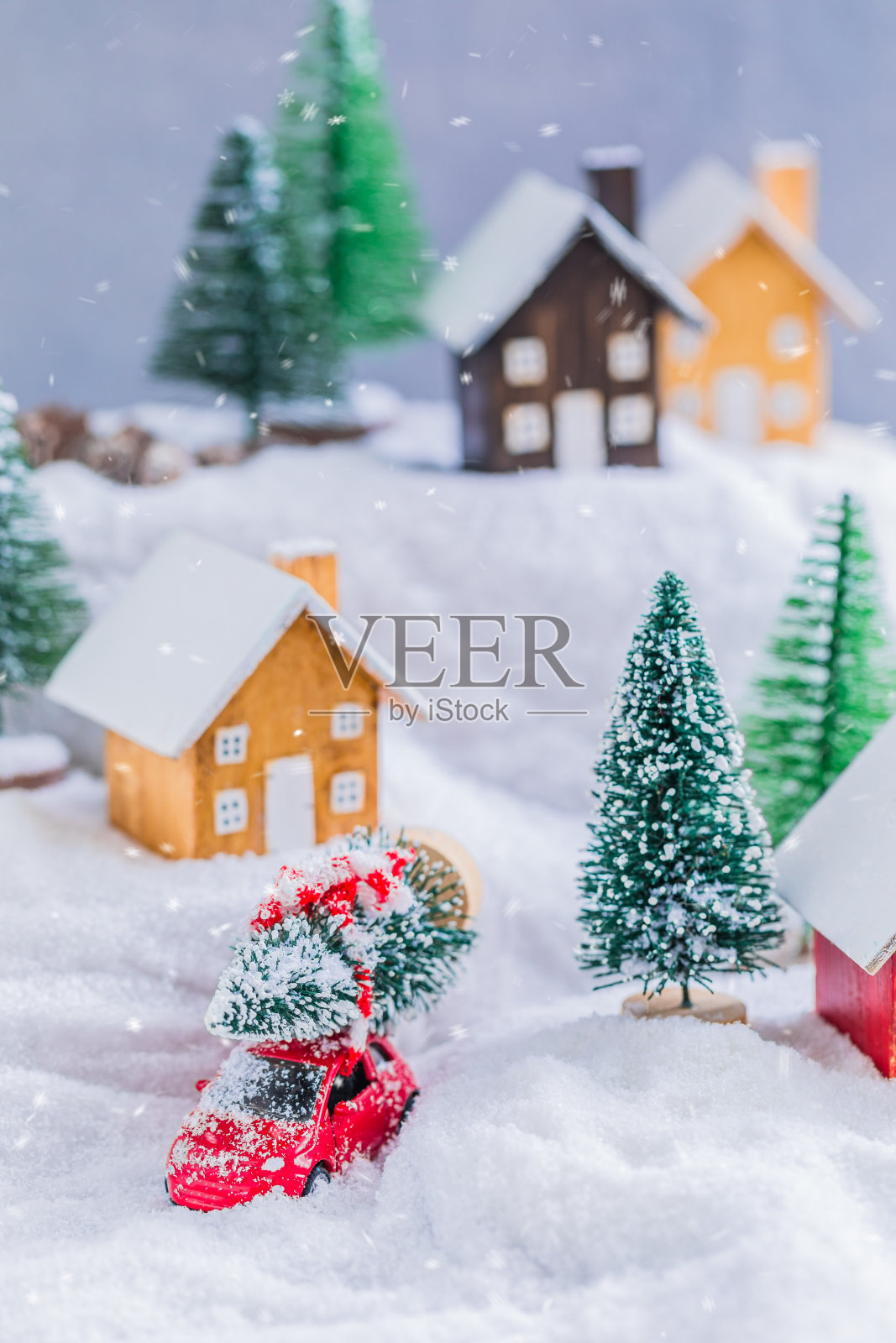 村里的小木屋在雪地上模糊了圣诞装饰的背景，色调照片摄影图片