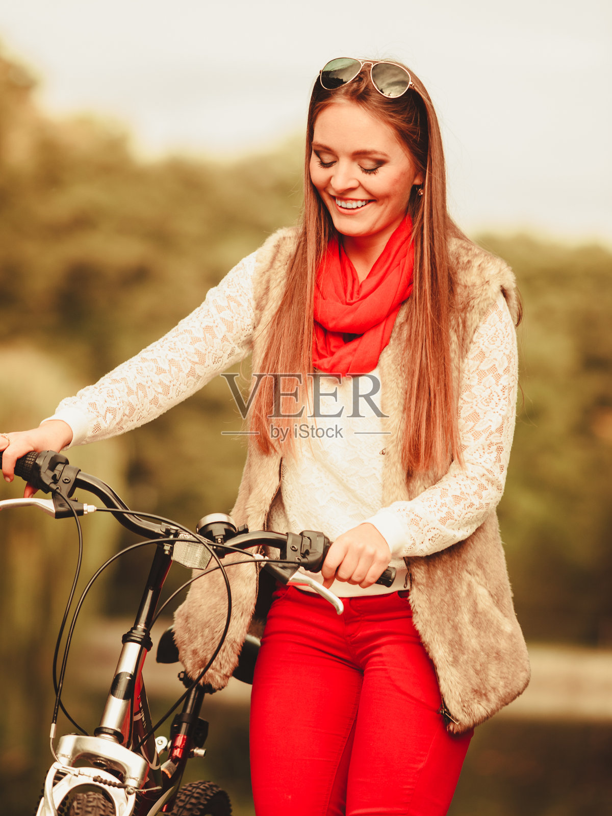 女孩在秋天的公园里骑自行车放松照片摄影图片