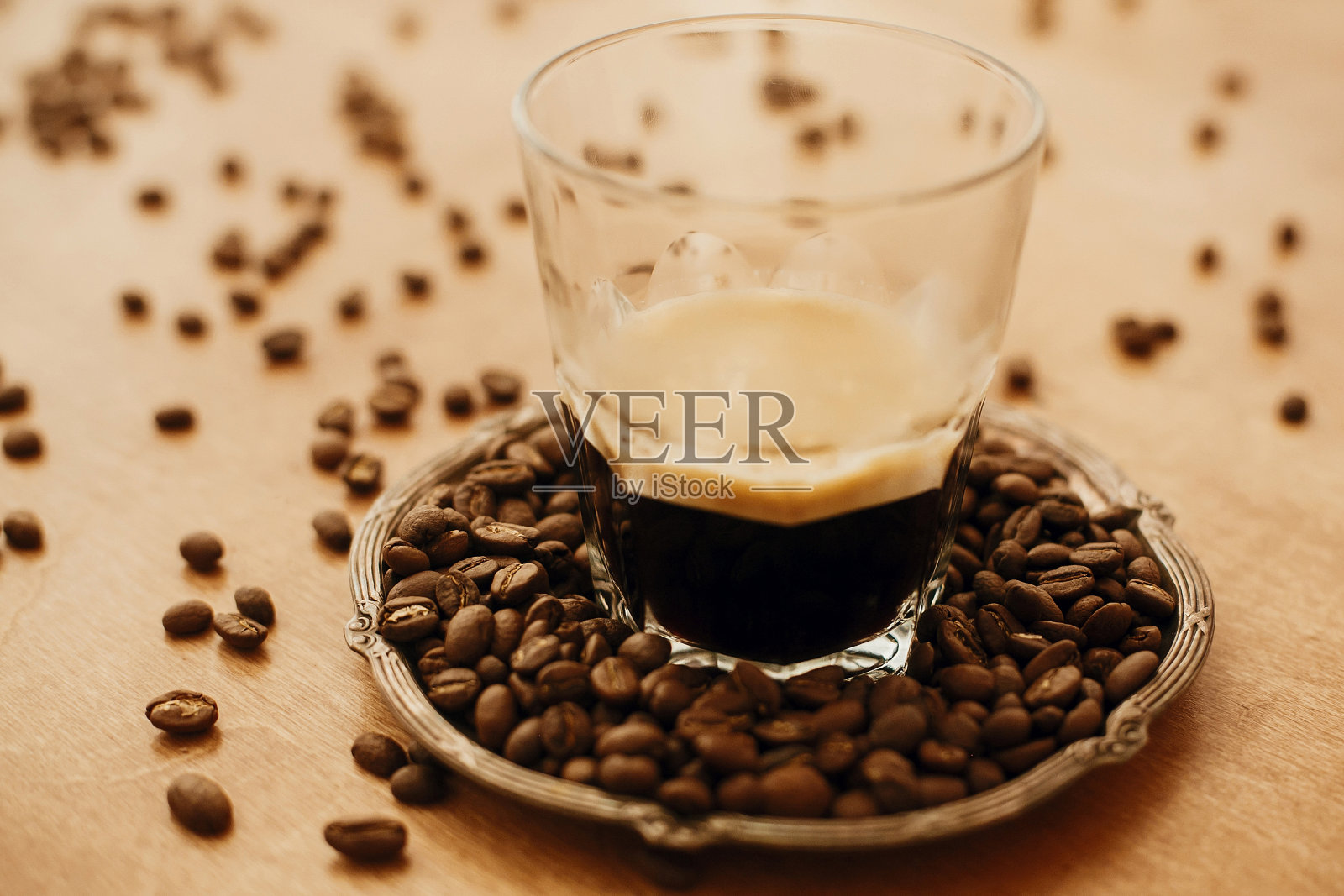 热咖啡和泡沫玻璃杯在古董盘子和芳香烤咖啡豆在木桌上。副本的空间。另类咖啡酿造概念。照片摄影图片