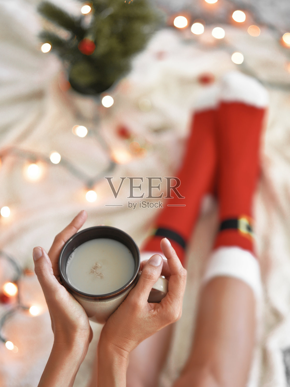 脚在圣诞老人的袜子附近的圣诞树照片摄影图片