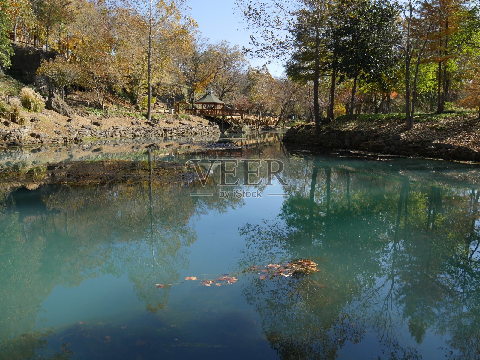 宽阔的镜头的河流与彩色的树木在秋天倒映在蓝色的水照片摄影图片