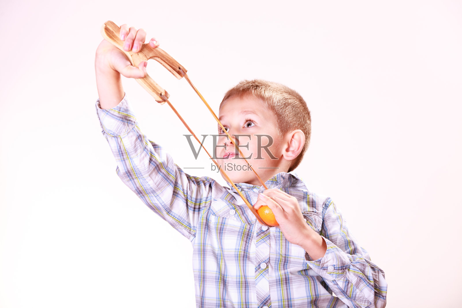 男孩用弹弓射击橘子照片摄影图片