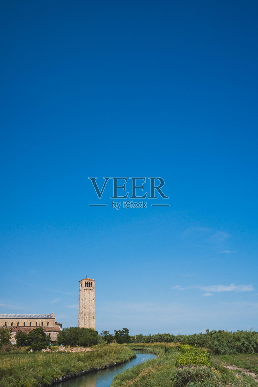 意大利威尼斯托切罗岛河边的圣玛丽亚·艾苏塔大教堂和钟楼照片摄影图片