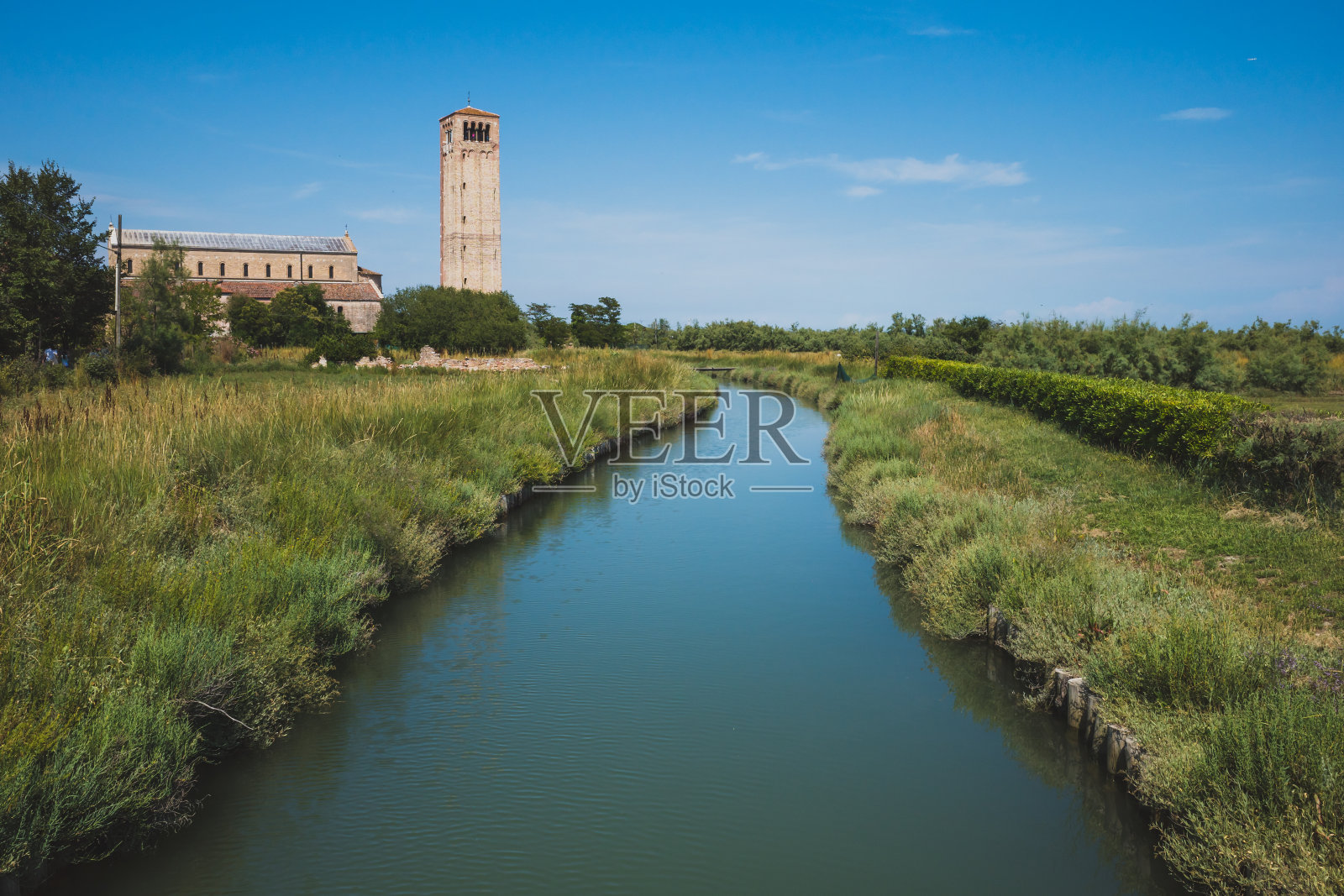意大利威尼斯托切罗岛河边的圣玛丽亚·艾苏塔大教堂和钟楼照片摄影图片