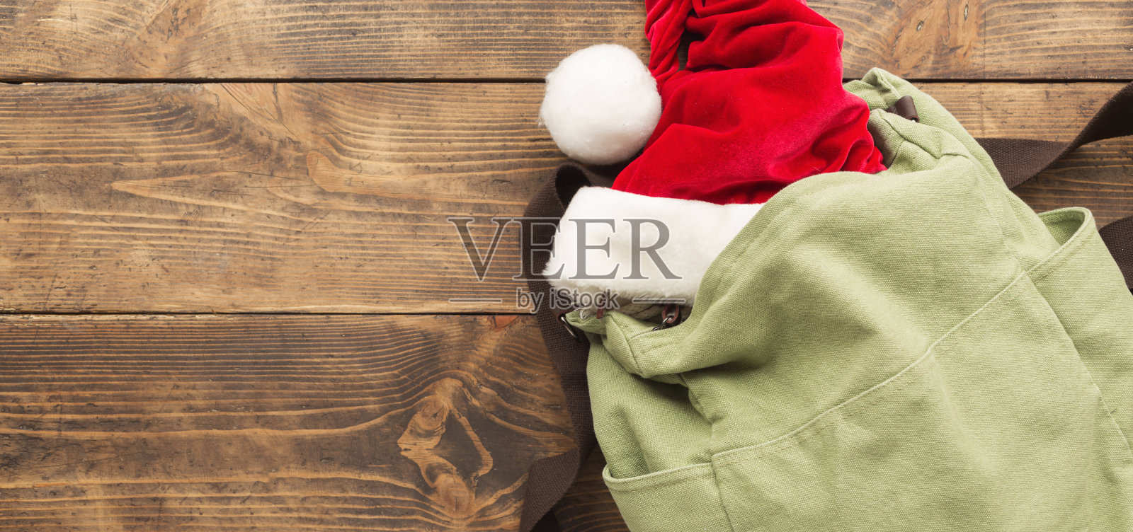 木桌上的复古背包和圣诞帽，假日旅行背景照片摄影图片