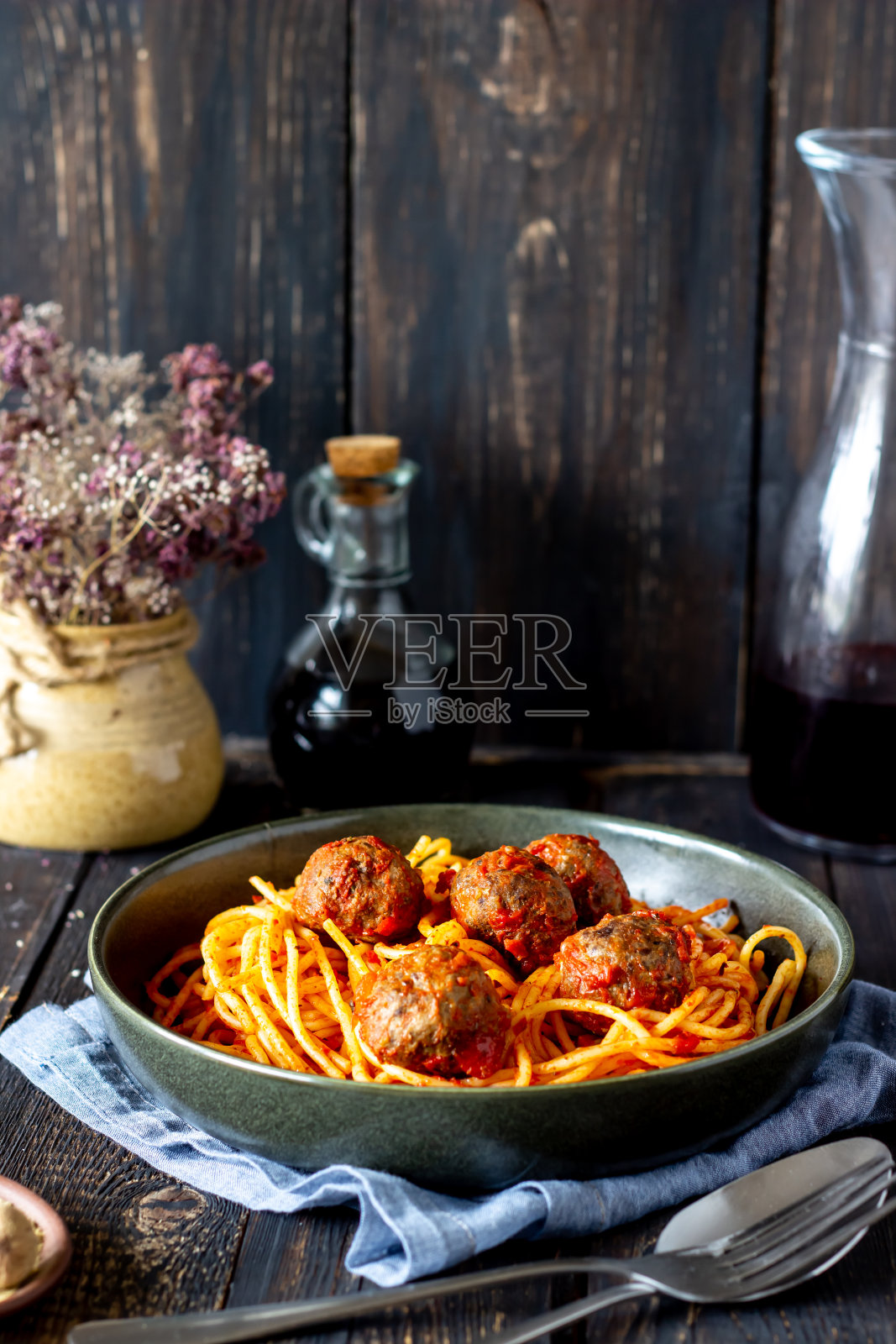 木色背景上的肉丸和番茄酱意大利面。照片摄影图片