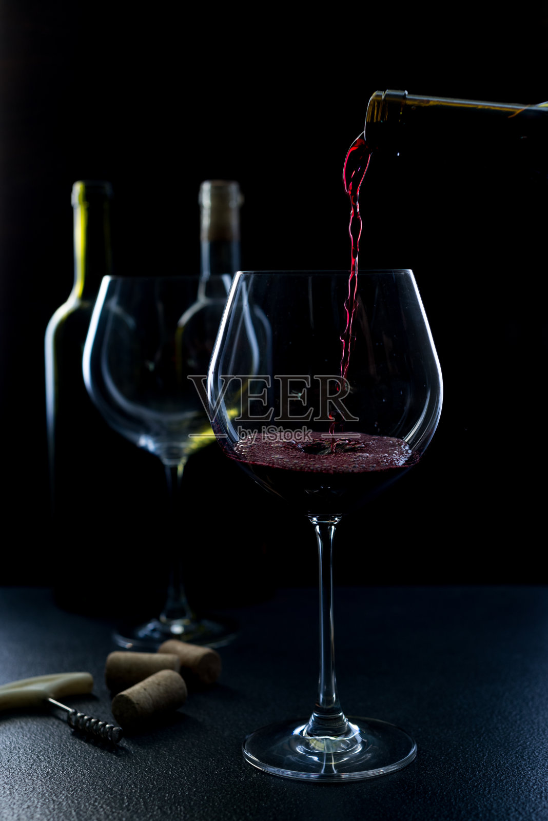 一杯红色和粉红色的葡萄酒在黑色的背景。葡萄酒菜单列表。近距离的力量的玻璃和瓶子在低的关键照片摄影图片