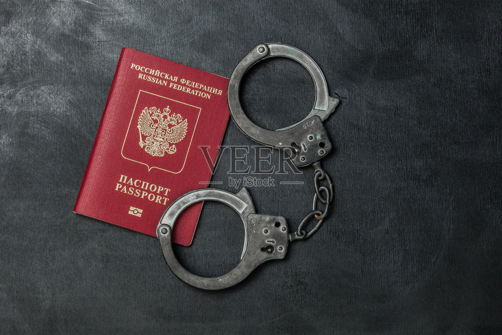 俄罗斯护照，黑色背景的手铐照片摄影图片