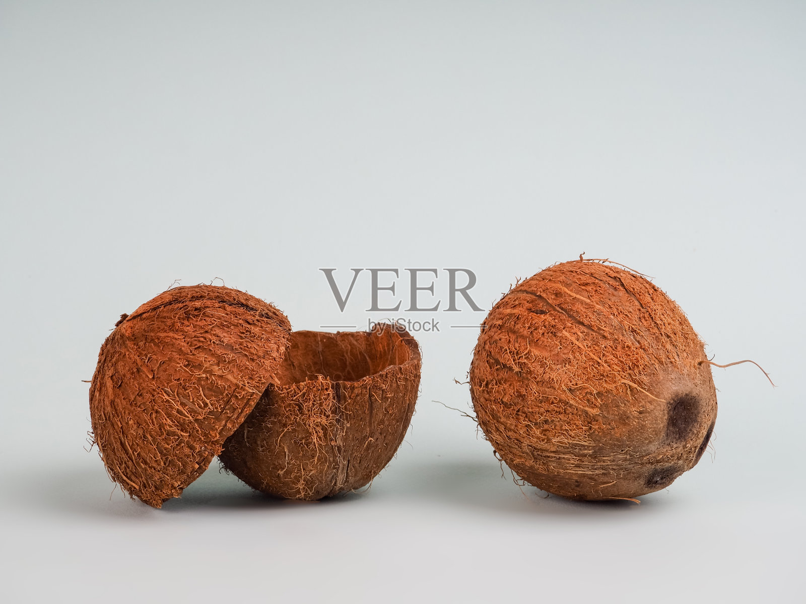 一个是完整的椰子，一个是在蓝色背景上破碎的。未来的食物碗零浪费。环保型餐具材料。副本的空间。照片摄影图片