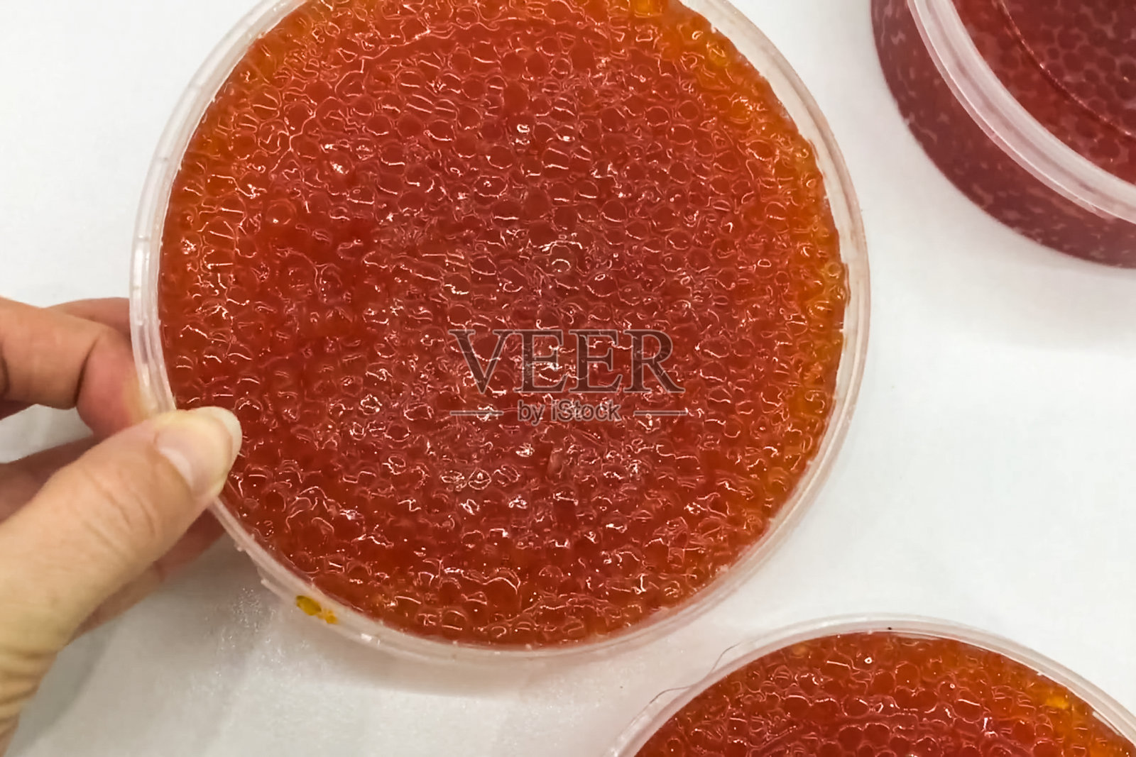 塑料容器里的红色鱼子酱。三文鱼鱼子酱，减肥食品。照片摄影图片