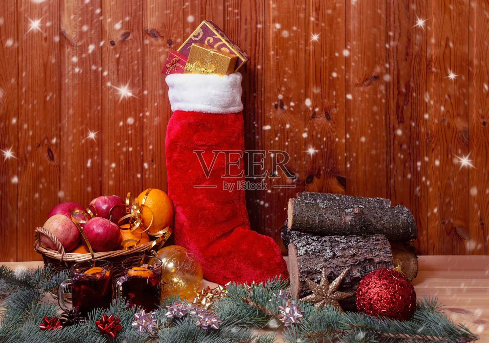 有水果的柳条篮子，蓬松的圣诞袜，热红酒，一堆木柴和圣诞球。照片摄影图片