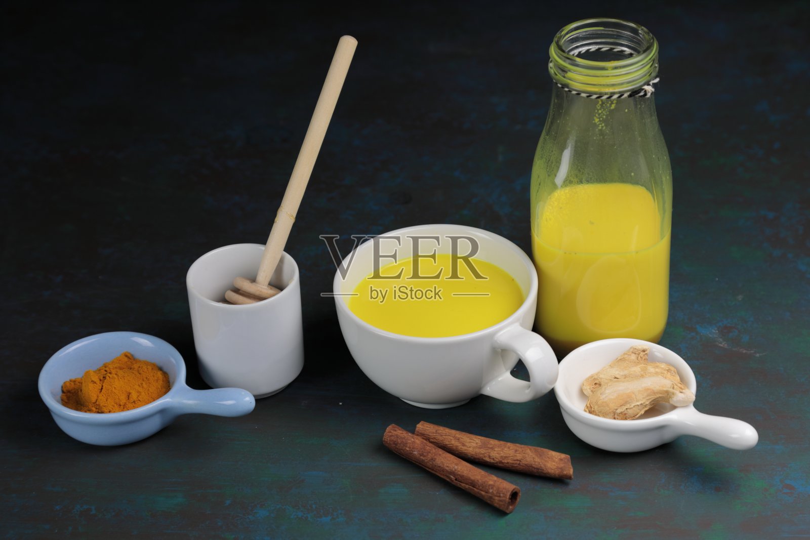 姜黄拿铁、黄金牛奶或含有超级食物姜黄粉、生姜和肉桂、蜂蜜加糖的印度抗炎Doodh照片摄影图片