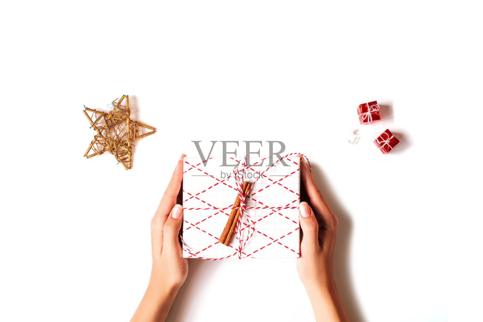 女人的手拿着礼盒在白色的背景。照片摄影图片