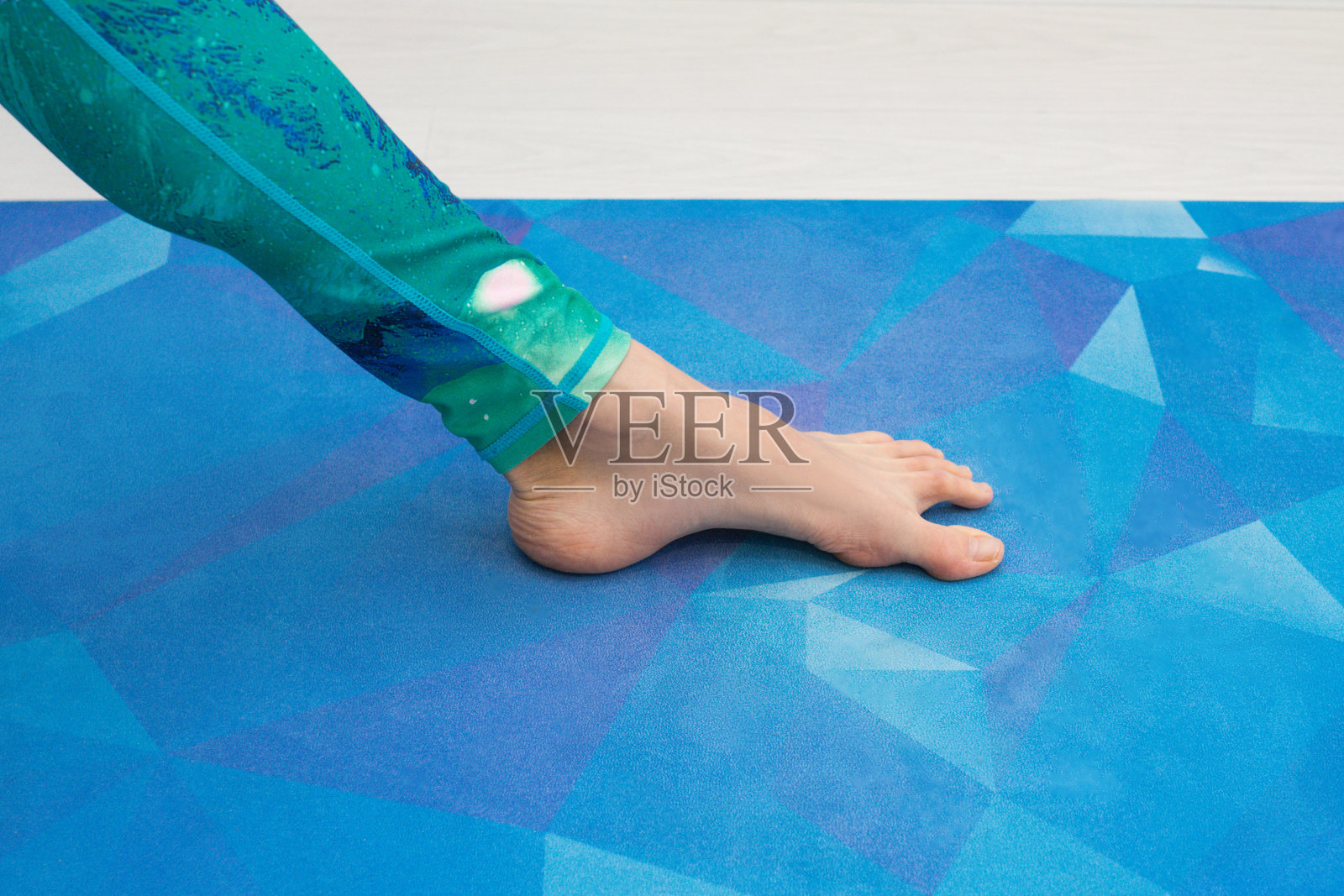 女孩的脚正确地站在瑜伽垫上。照片摄影图片