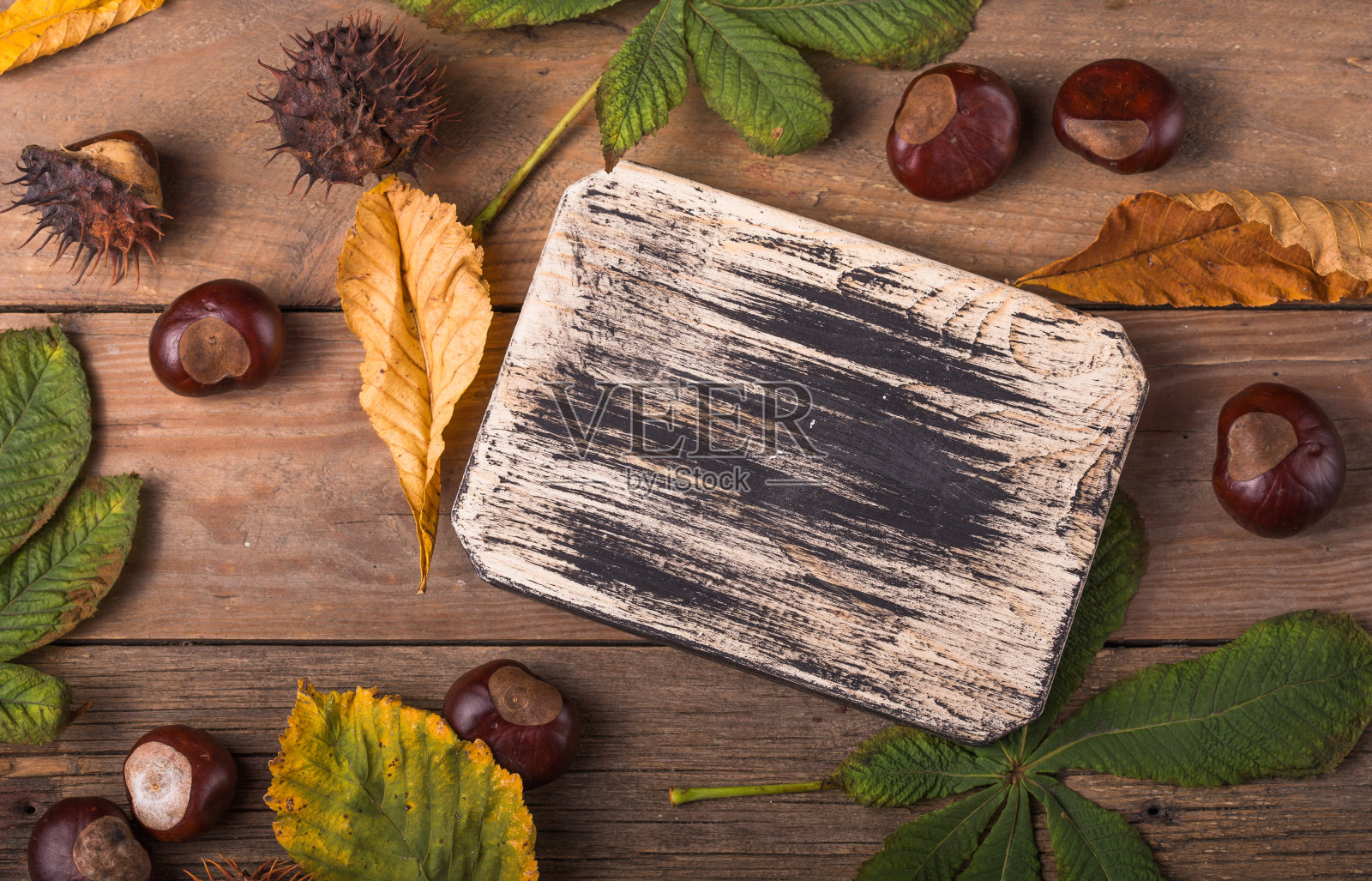 空木切菜板，切菜板，食物复古黑色背景。秋天的概念与栗子照片摄影图片