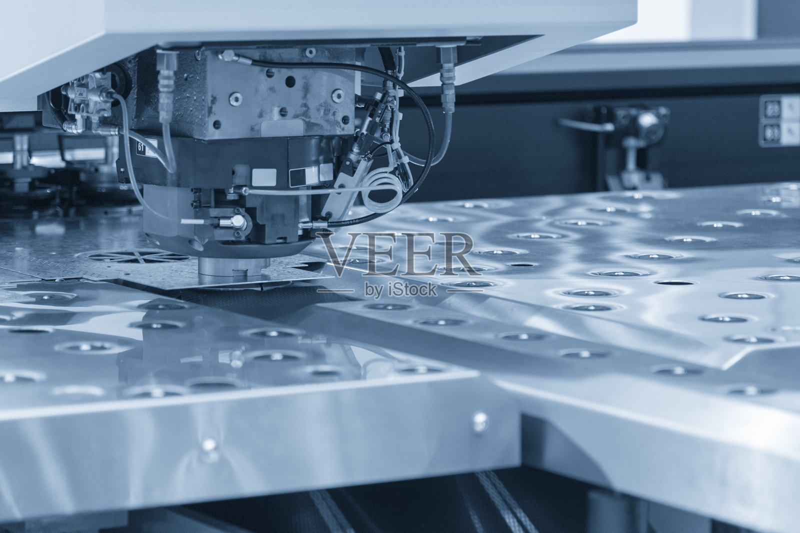 数控程序控制下的金属板材高速转塔冲床冲孔照片摄影图片