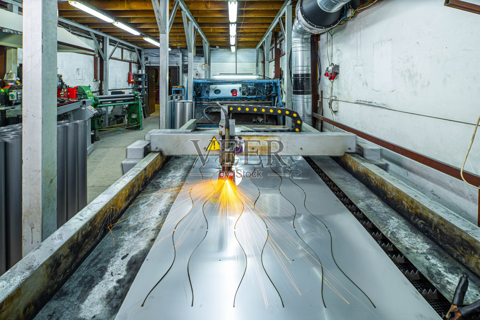 金属的等离子切割。前视图的工作机器与金属板。金属加工。照片摄影图片