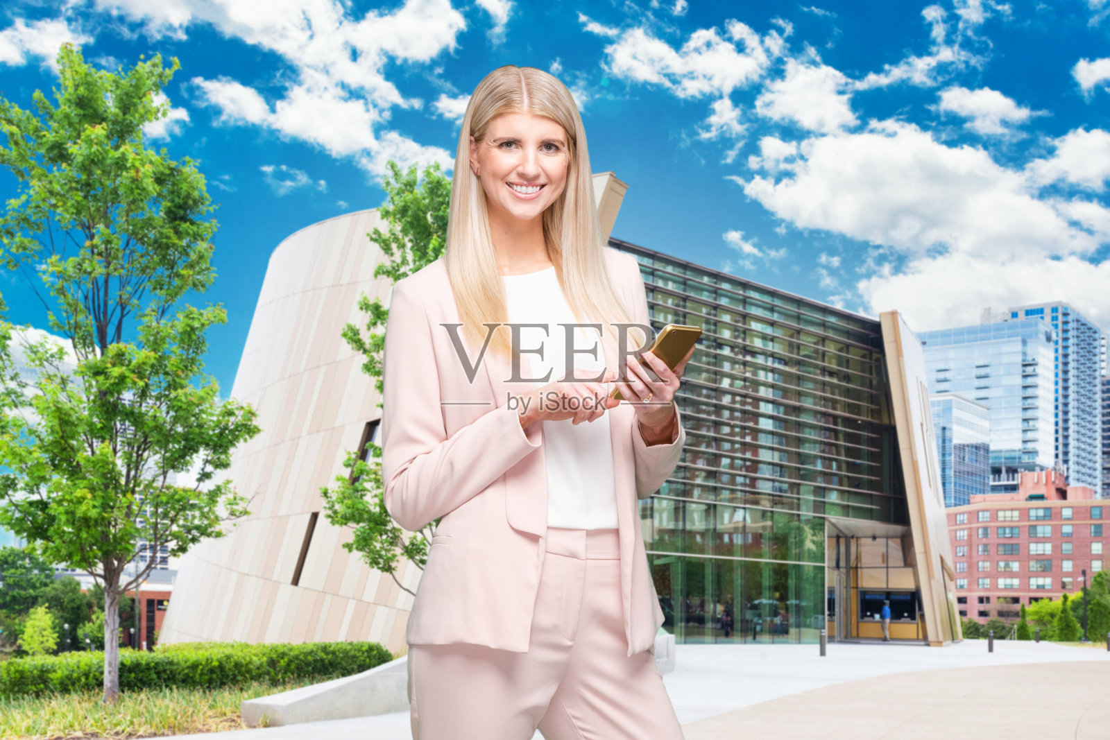 一个人/腰部以上/正面/看相机的20-29岁的成年漂亮的金发白人女性/年轻女性商人/商人穿着商务装/套装站在微笑/快乐/愉快/大笑照片摄影图片