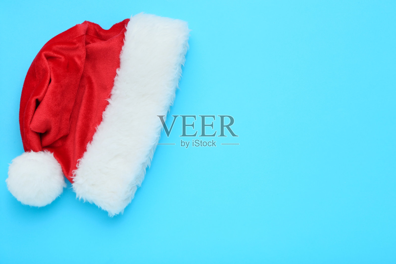 蓝色背景上的红色圣诞帽照片摄影图片