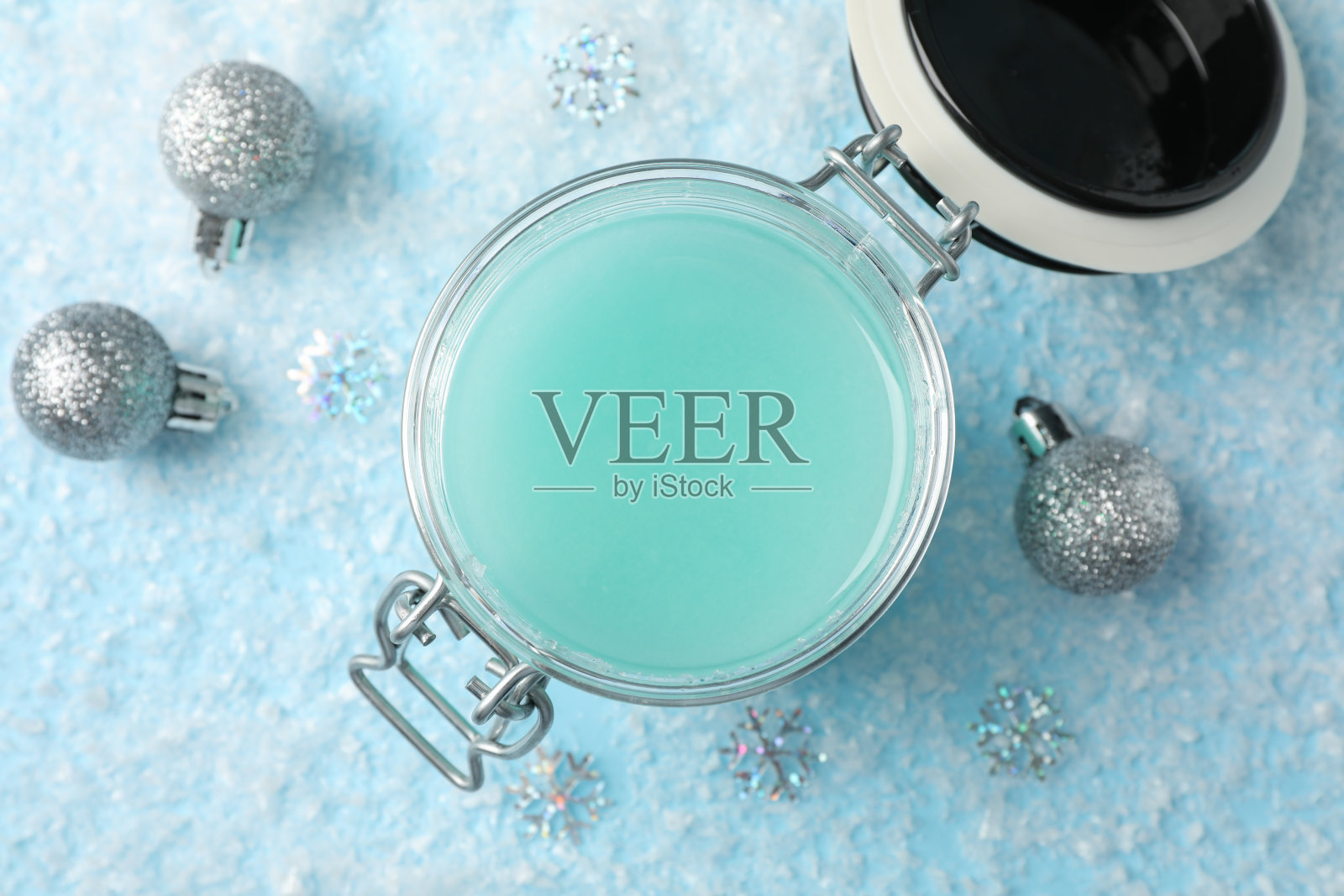 雪蓝背景，文字空间的冬季护肤霜的罐子。俯视图照片摄影图片