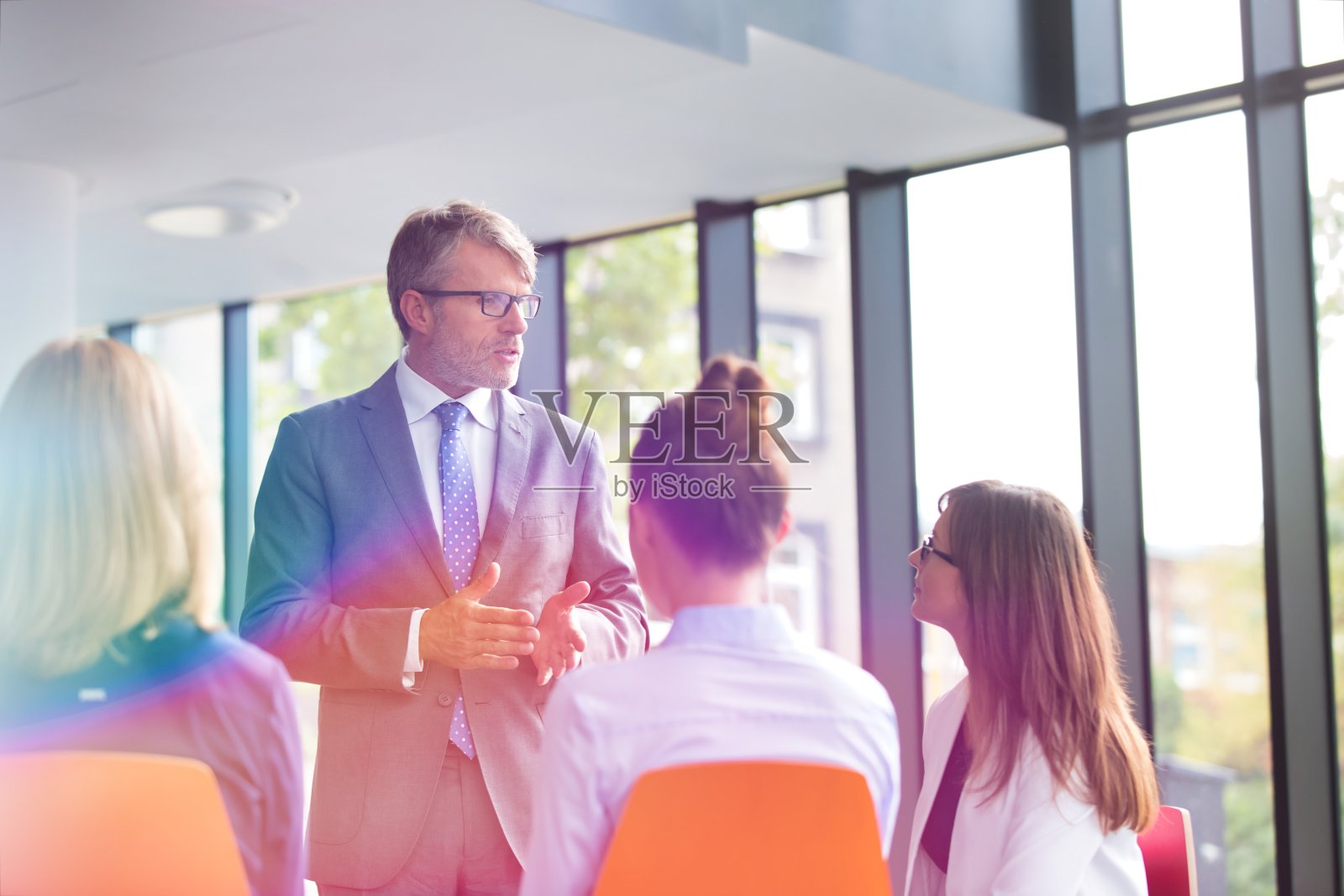 中年商人与办公室同事讨论计划照片摄影图片