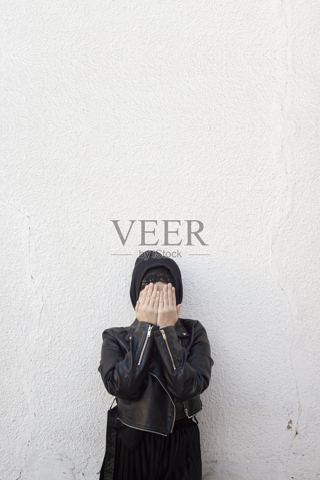 用手遮住脸的年轻穆斯林女孩，家庭暴力和虐待的受害者。阿拉伯妇女用手遮住脸，感到羞愧照片摄影图片