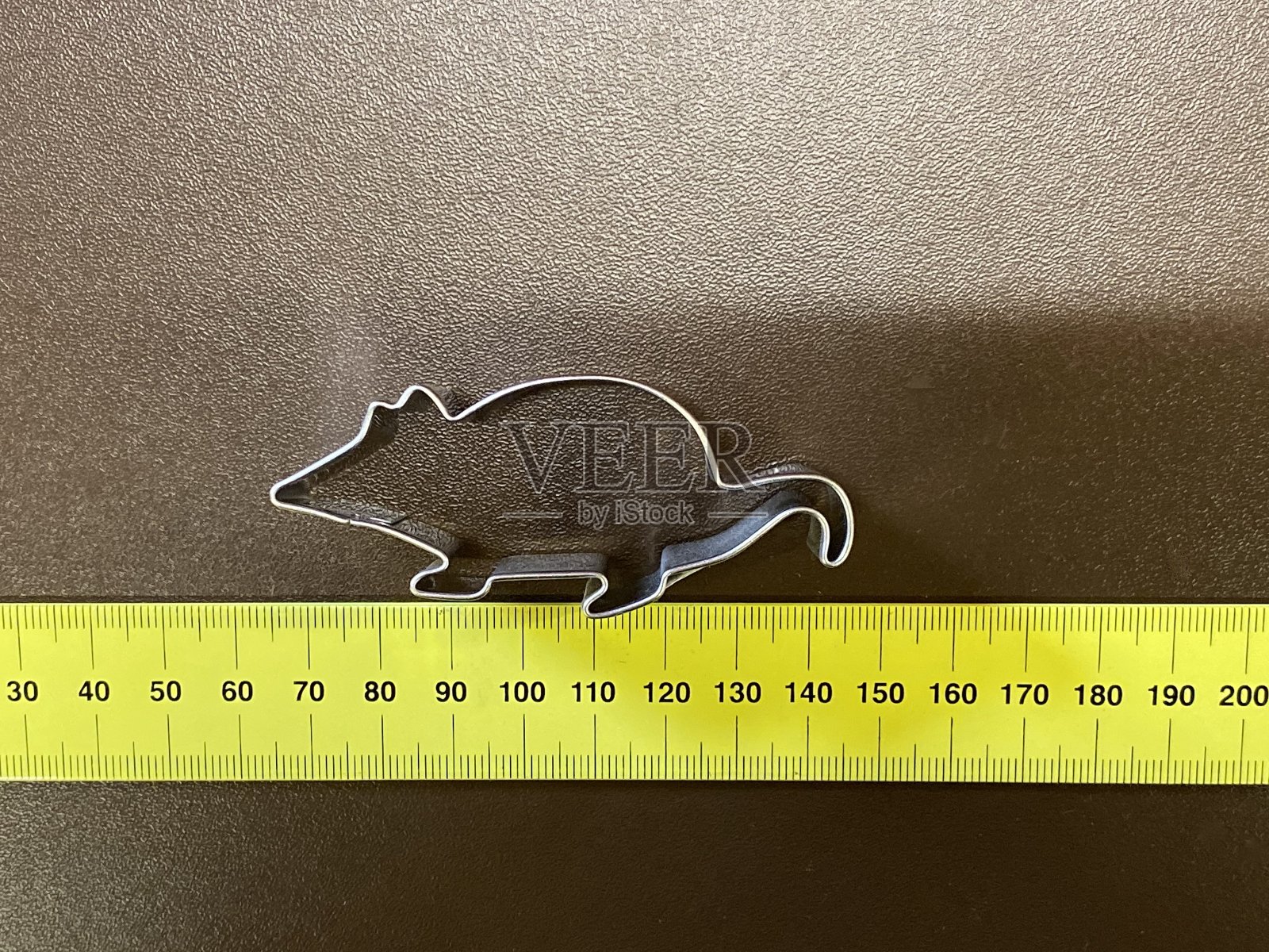 黄色卷尺上的鼠标(饼干切割器)照片摄影图片