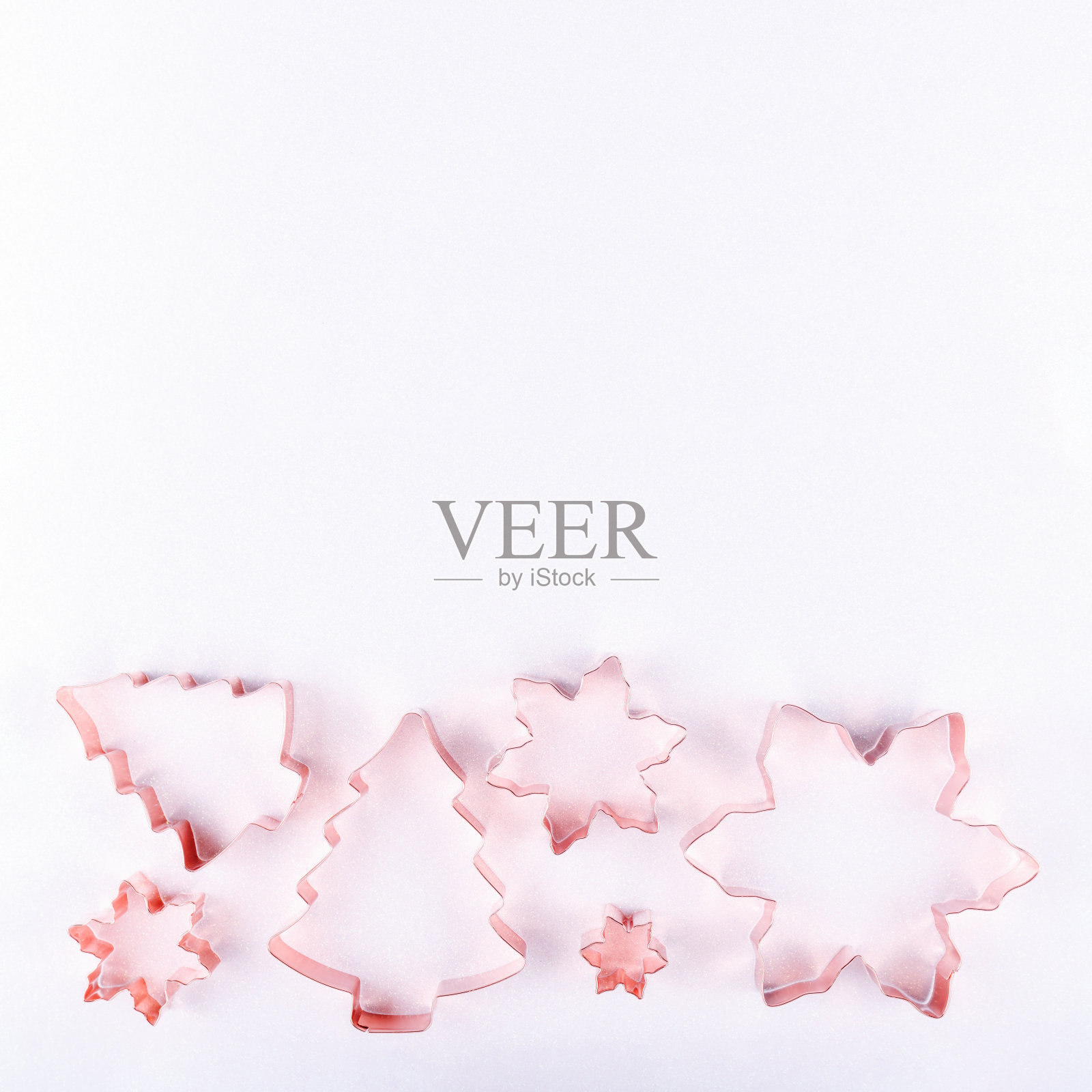 扁平的假日树和雪花铜饼干切割机在白色闪闪发光的背景。假日，圣诞节和新年的概念。舒适自在的细节照片摄影图片