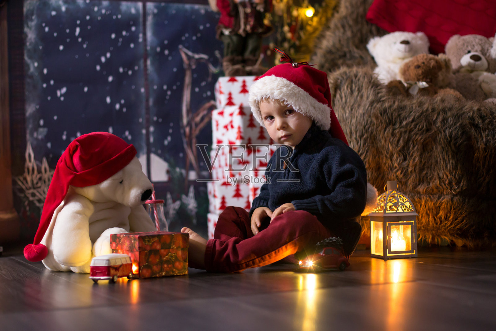 可爱的幼儿男孩在圣诞节晚上在家玩木制火车照片摄影图片