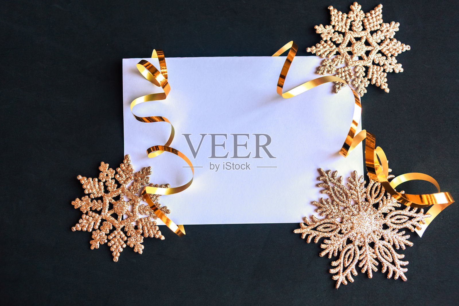 白色模型空白和金色圣诞装饰在黑色的背景。漂亮的圣诞贺卡。为文本复制空间照片摄影图片