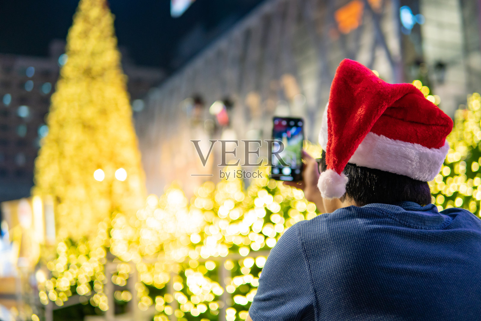 戴着圣诞帽的男人在圣诞活动中拍照照片摄影图片