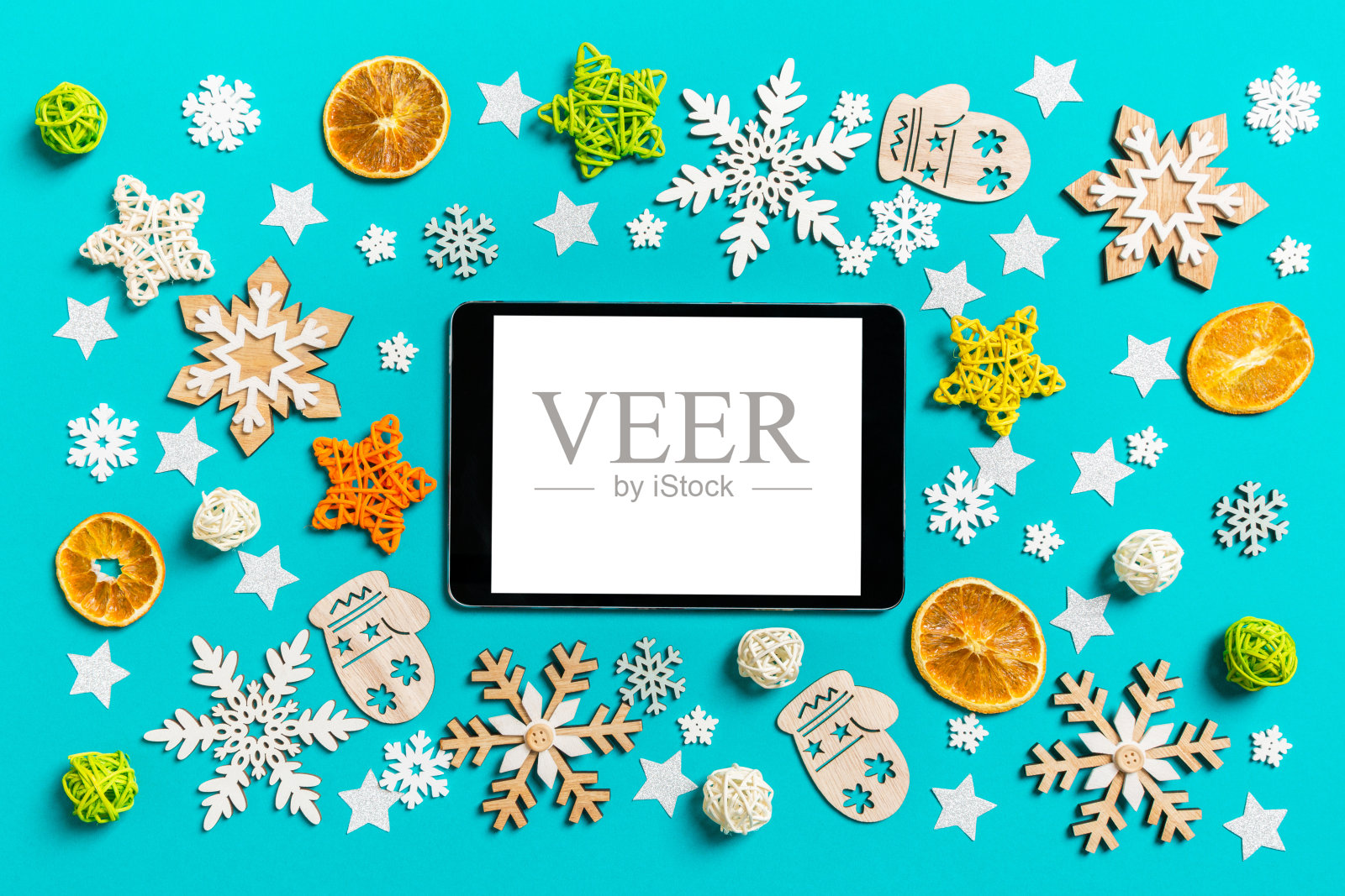 俯视图的数字平板电脑在蓝色背景与新年玩具和装饰。圣诞节的时间概念照片摄影图片