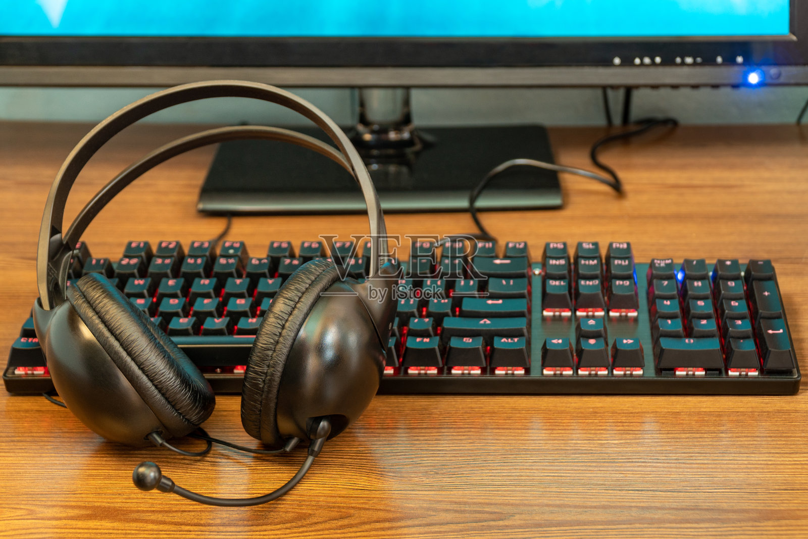 桌上放着键盘和耳机照片摄影图片