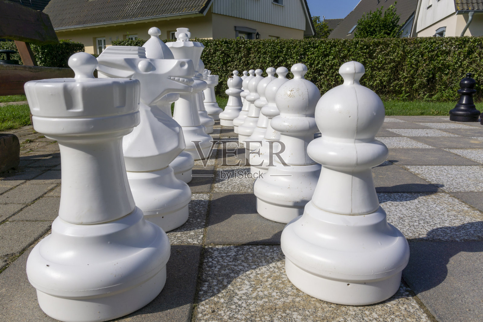 带有大塑料棋子的户外棋盘。照片摄影图片