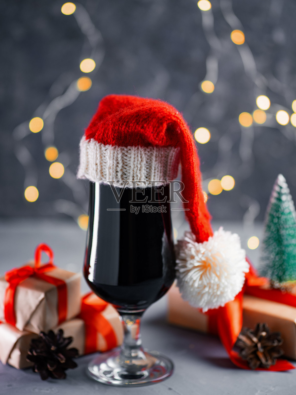 圣诞帽黑啤酒玻璃杯，节日背景装饰照片摄影图片