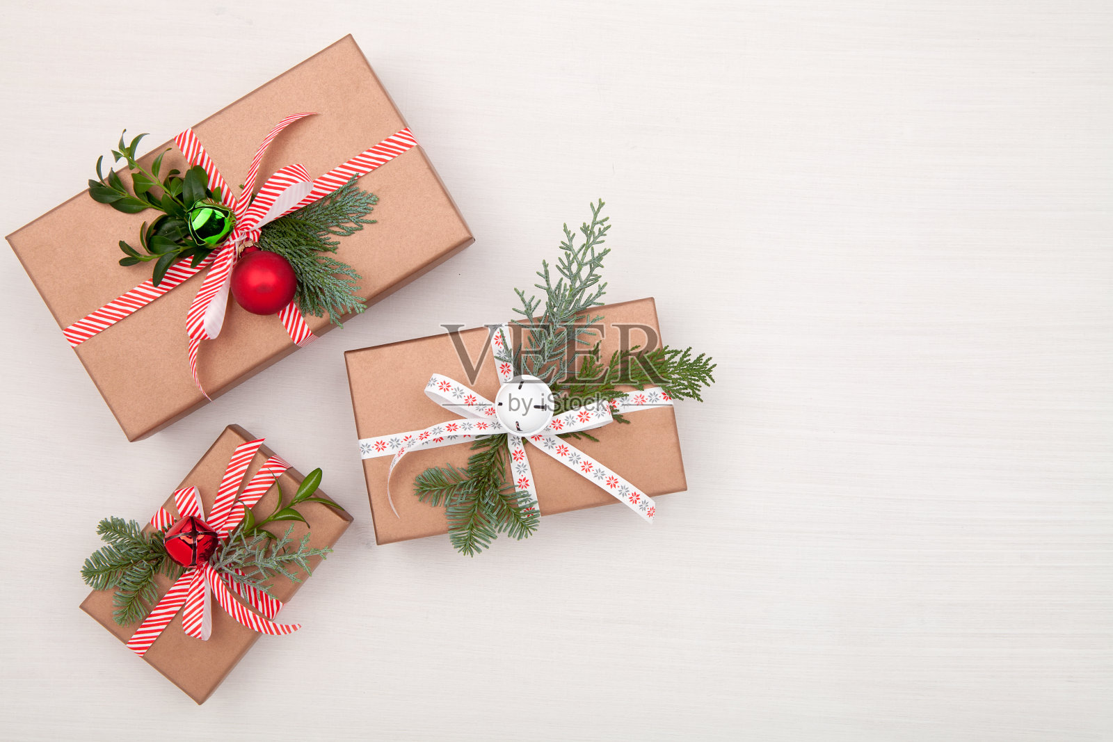 圣诞礼盒以白底装饰冷杉树枝和铃铛。圣诞节，冬天，新年的概念。平铺，俯视图，拷贝空间照片摄影图片