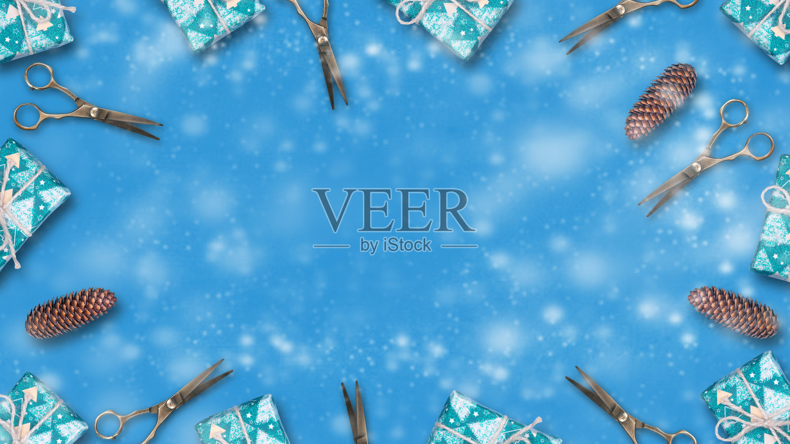 蓝色背景，新年礼物、松果与理发剪刀。照片摄影图片