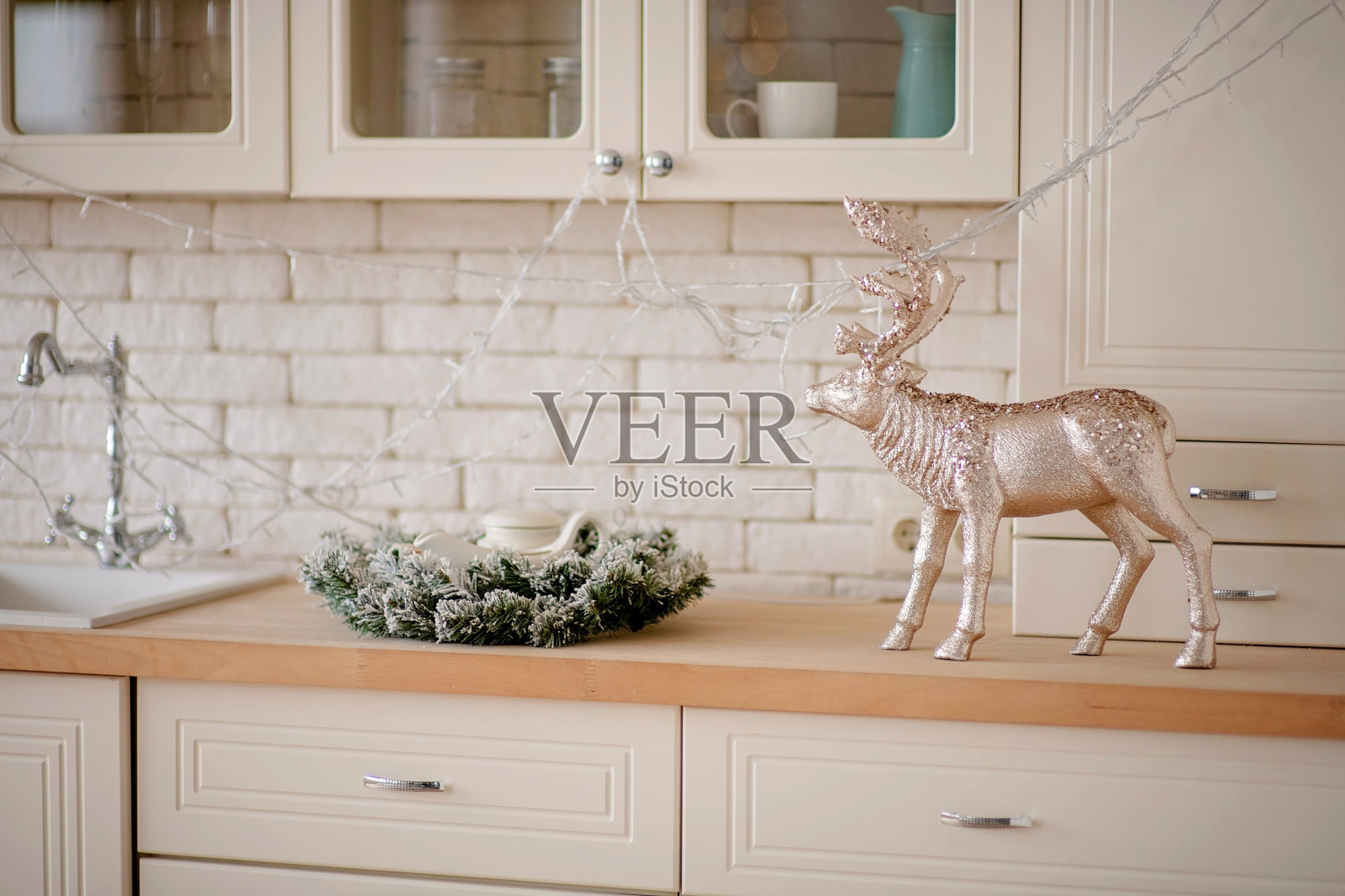 节日的冬季舒适的厨房室内花环，装饰和礼物。圣诞晚餐在装饰的桌子上。照片摄影图片