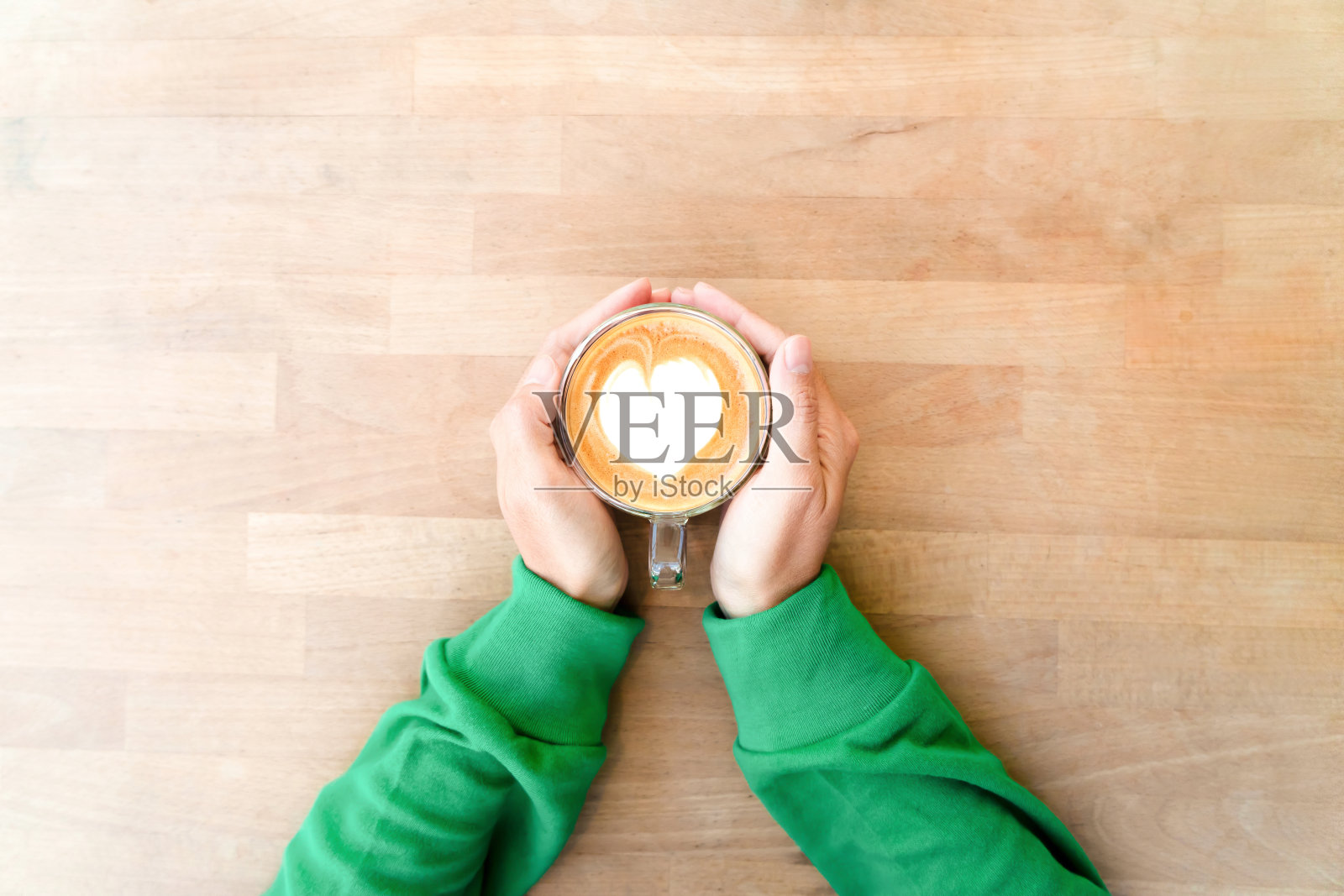 手持心形奶泡热咖啡照片摄影图片