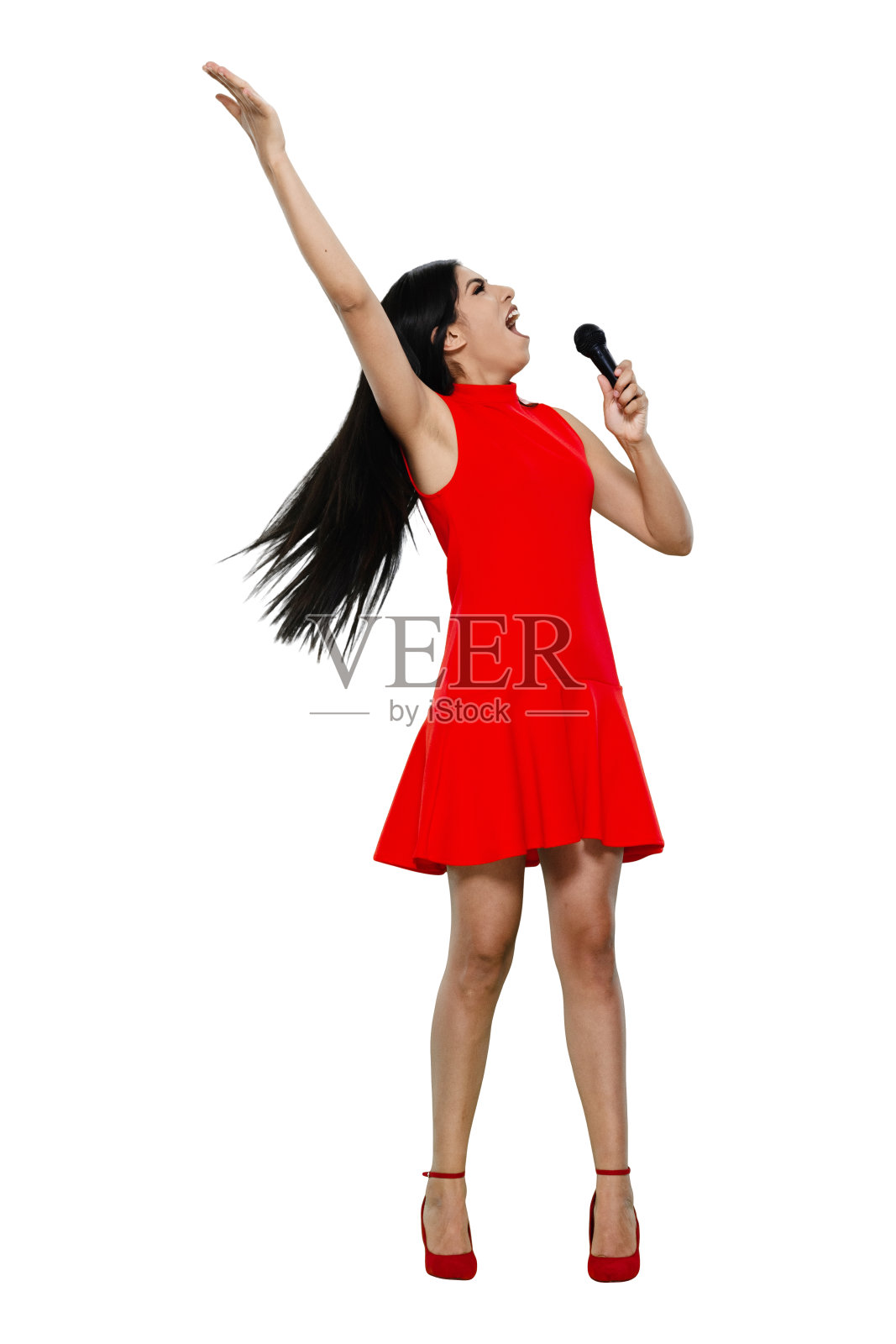 全长/正面视图/一个20-29岁的成年人美丽的黑发/长发拉丁美洲和西班牙裔的种族女性/年轻女性歌手站着/穿着裙子和高跟鞋跳舞/凉爽的态度和拿着麦克风照片摄影图片