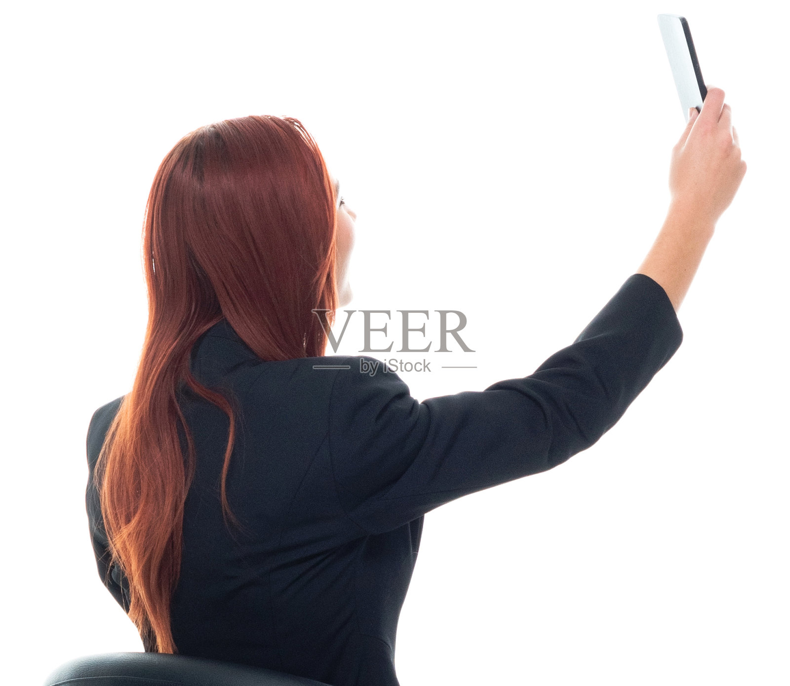 后视图/后/一人/腰部以上/ 20-29岁的成年人的肖像漂亮的红发/长发白人女性/年轻女性商人/商务人士穿着商务装/西装和拿着手机/使用智能手机照片摄影图片