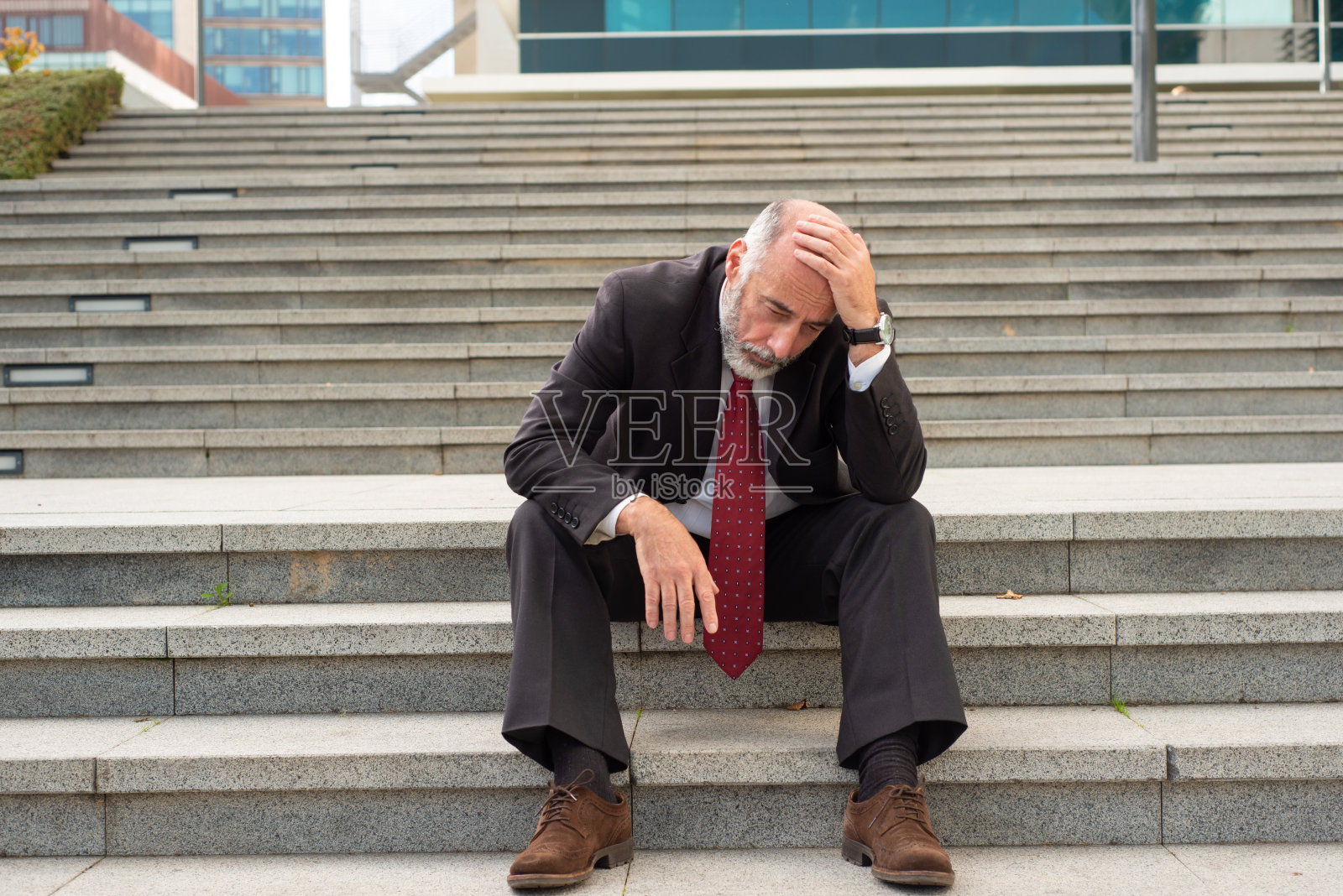 沮丧的商人坐在台阶上照片摄影图片