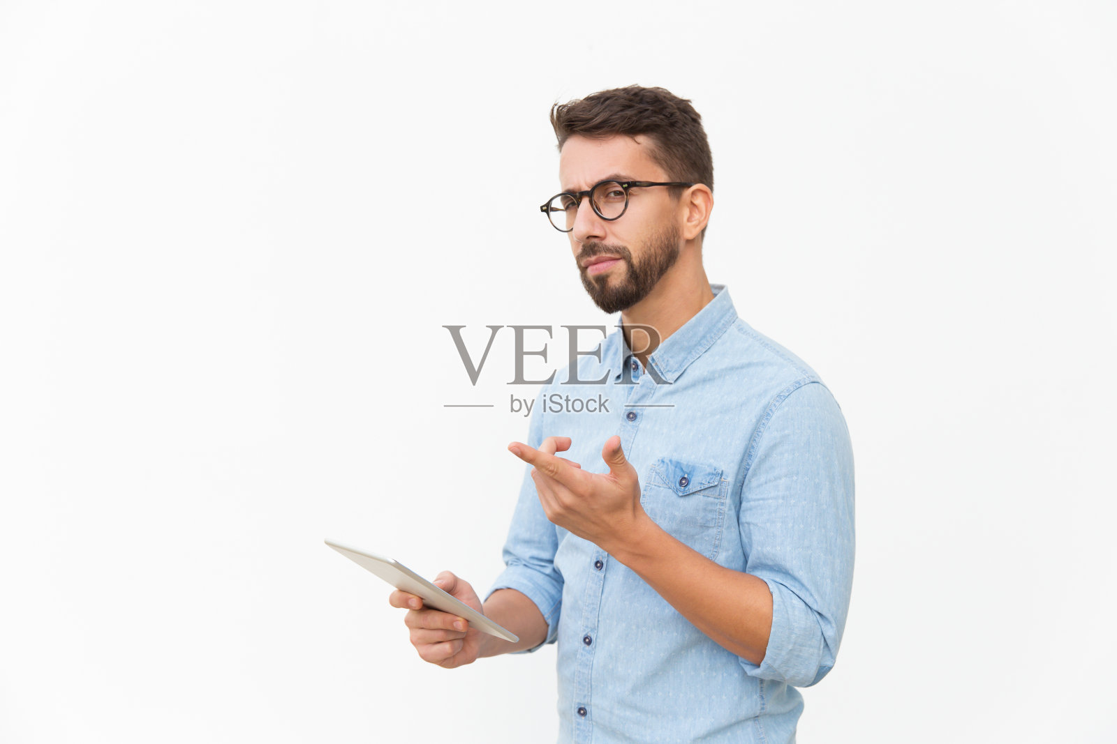 看着相机并指向远方的沉思平板电脑用户照片摄影图片