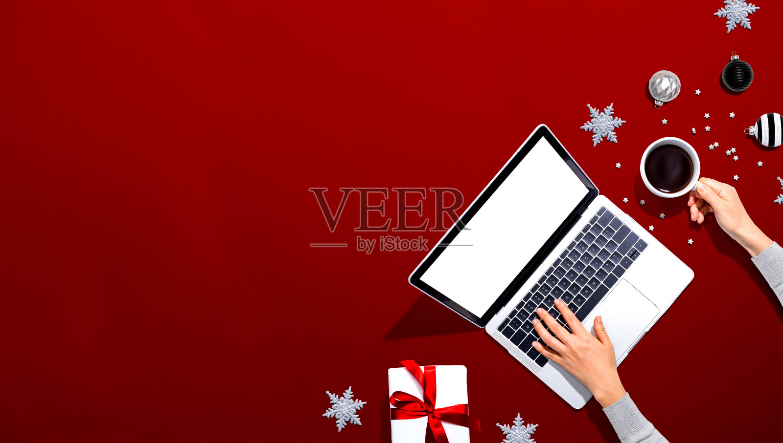 圣诞装饰品与使用笔记本电脑的人照片摄影图片